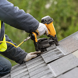 Roof Repair photo of a man on roof installing shingles